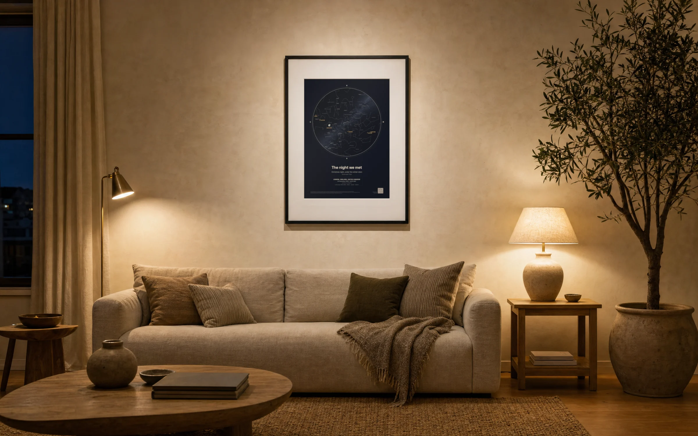 A framed midnight navy star map print above a sofa in a softly lit living room