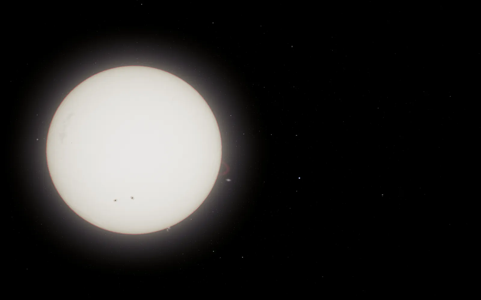 The Sun in the viewer, a white disc darkening towards its edge with two small sunspots, against black space